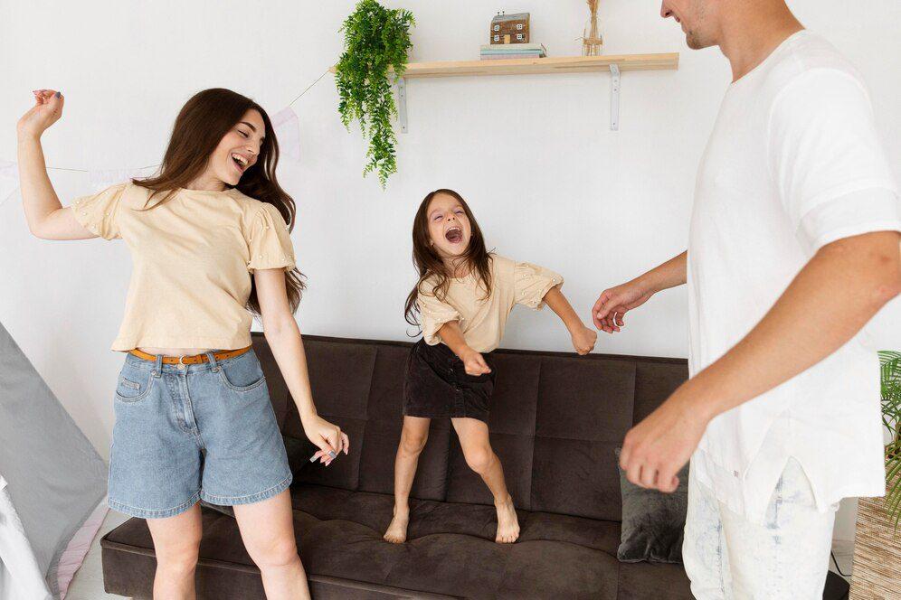 Parents and their child dancing freely to different types of music.